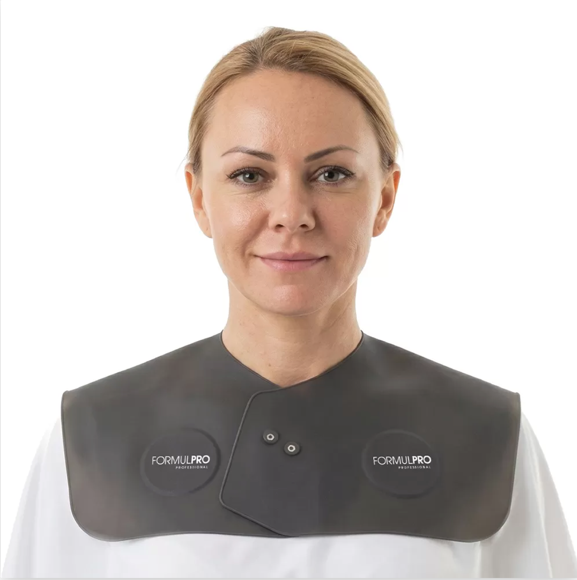 Woman smiling against a wooden background, wearing a black protective cover on her shoulders.